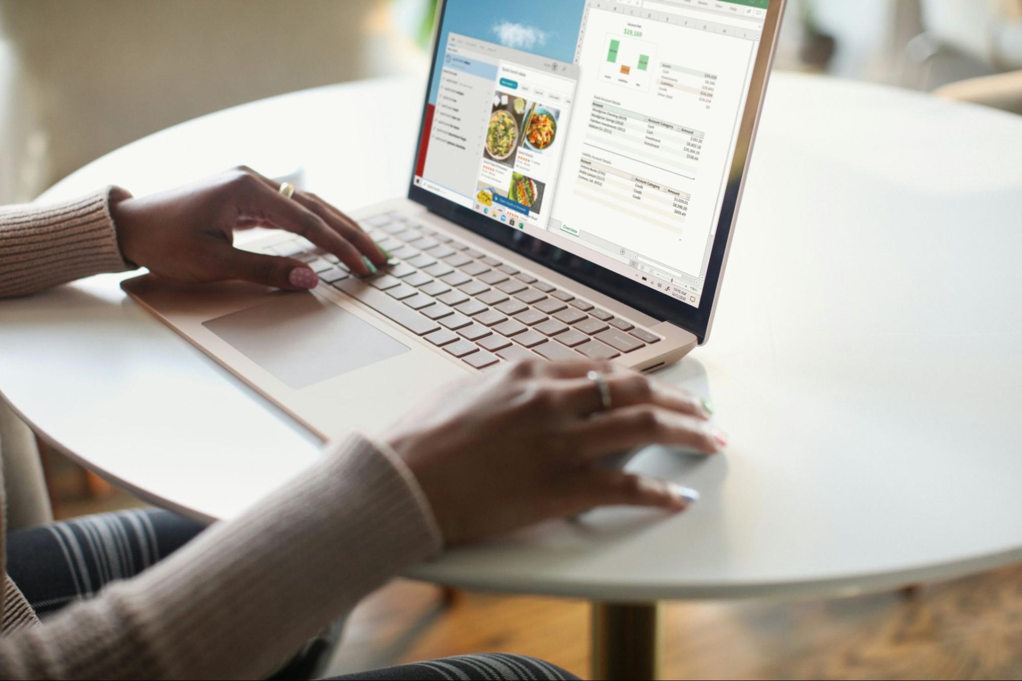 Close-up of person's hands and their laptop on a table