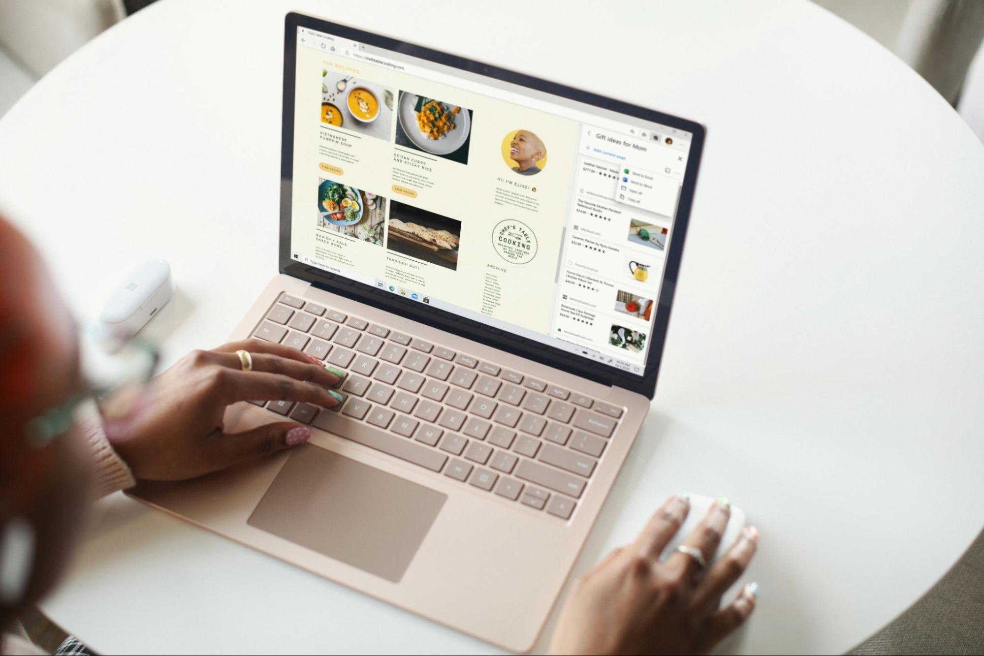 Close-up of a person using a laptop with recipe cards on their screen
