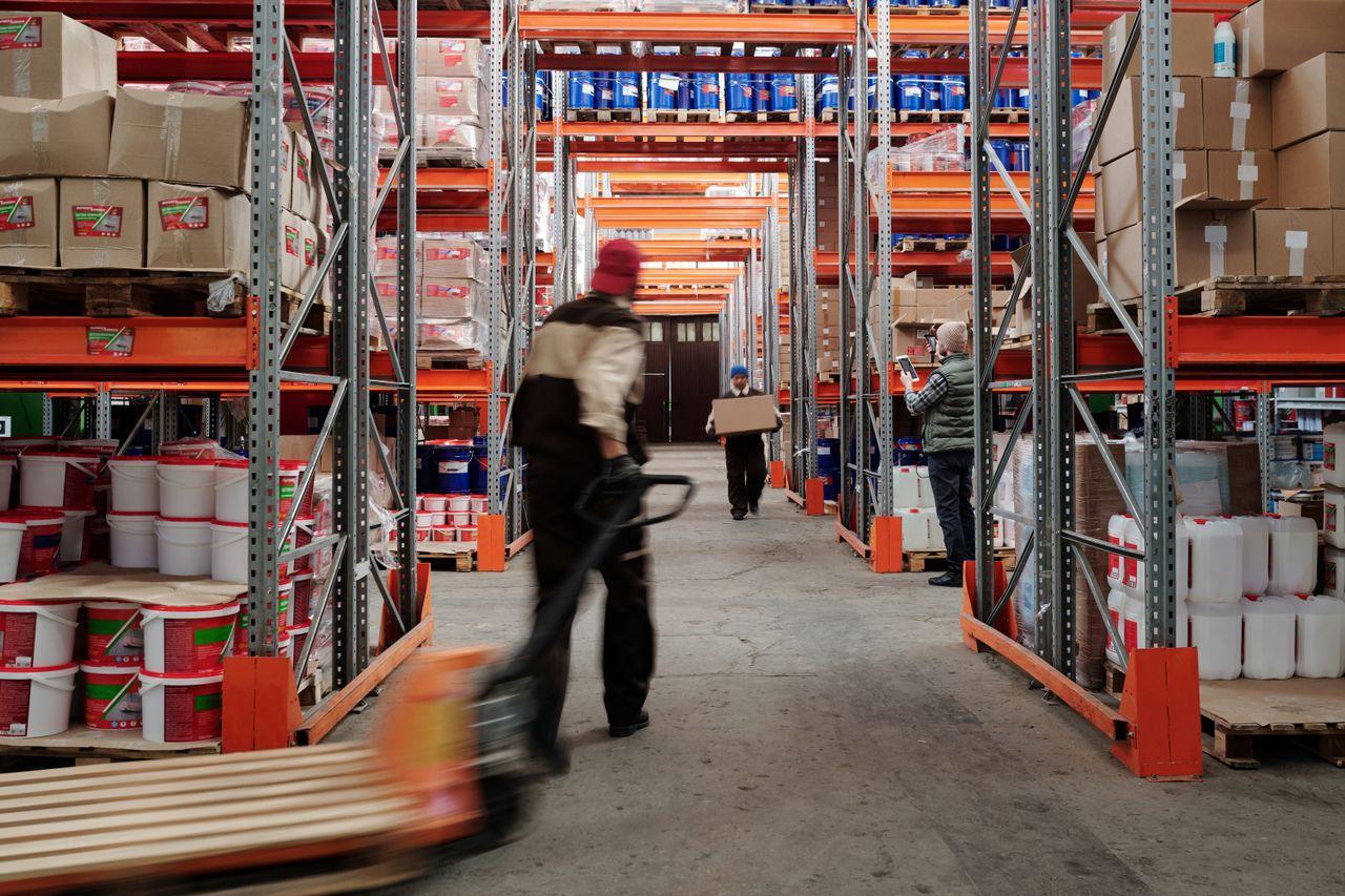 person pulling a wooden pallet in a warehouse